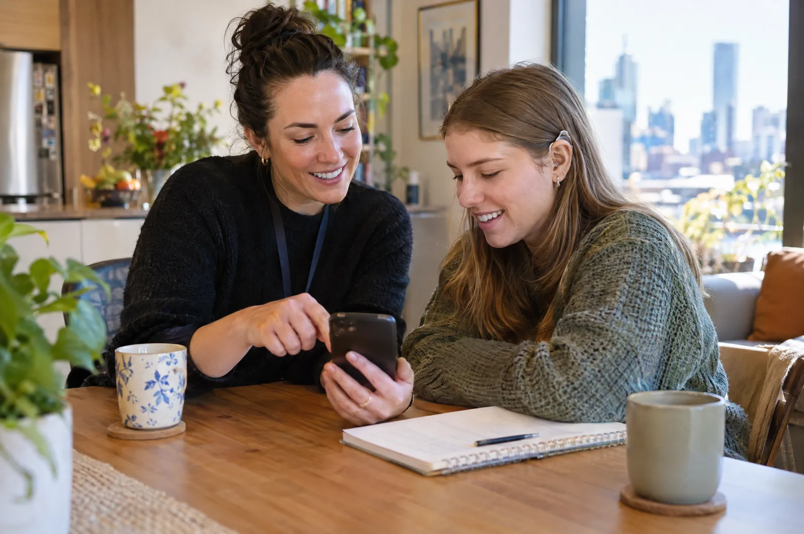 A support worker and a young woman planning the week together on a phone